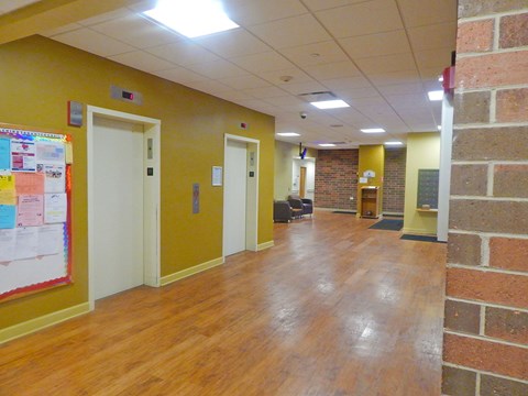 a large room with a wood floor and a brick wall