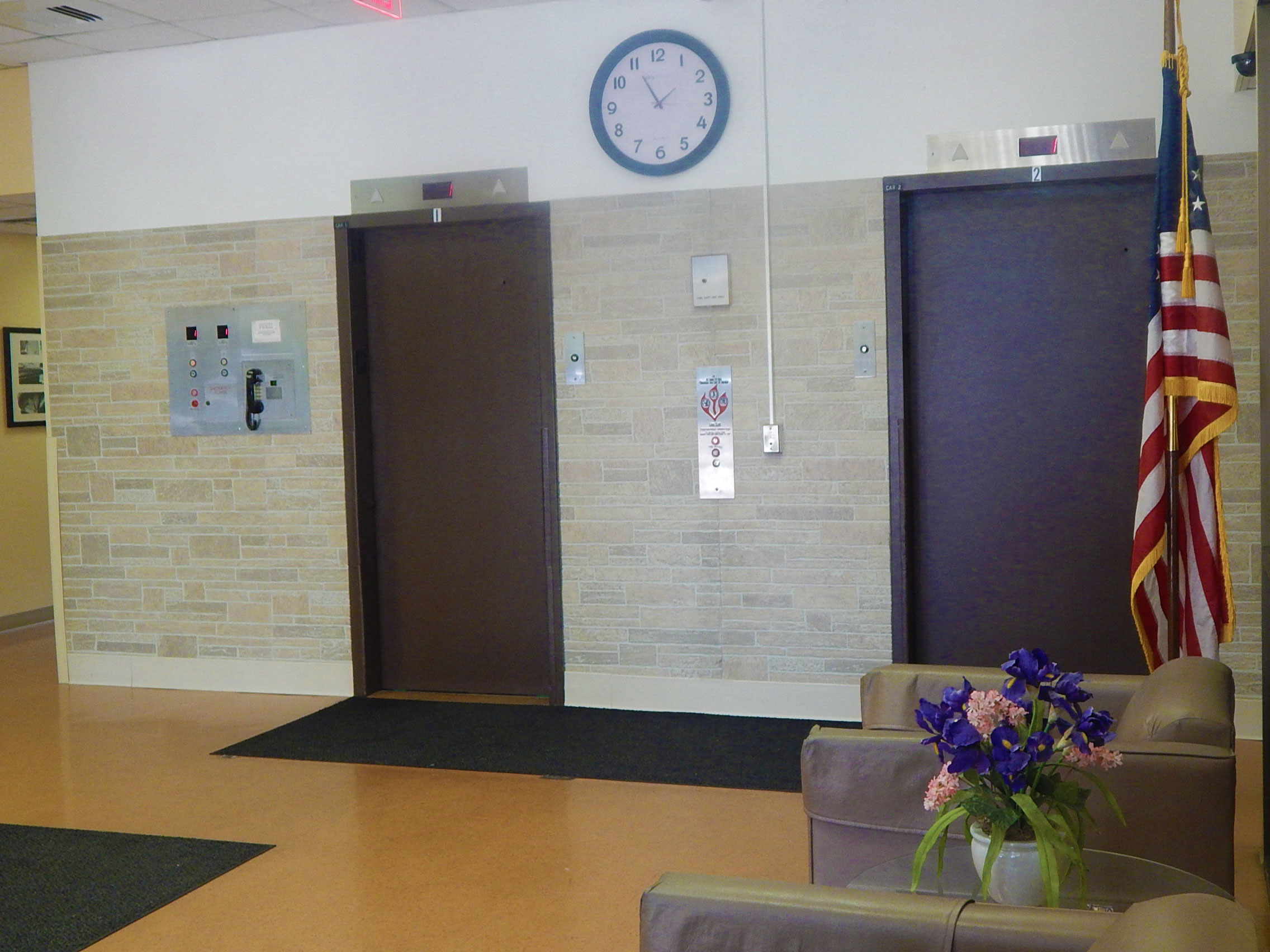 a lobby with two doors and a clock on the wall