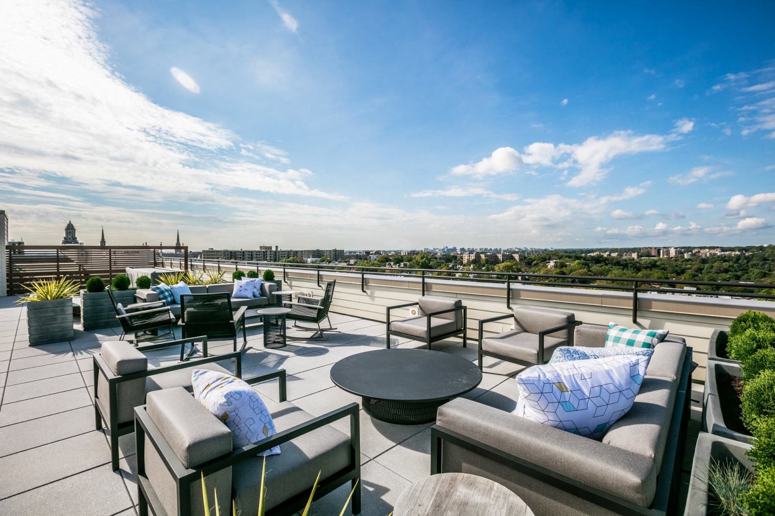 a rooftop terrace with couches and tables overlooking the city