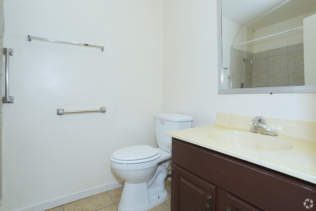 A white toilet sits in a bathroom next to a sink.