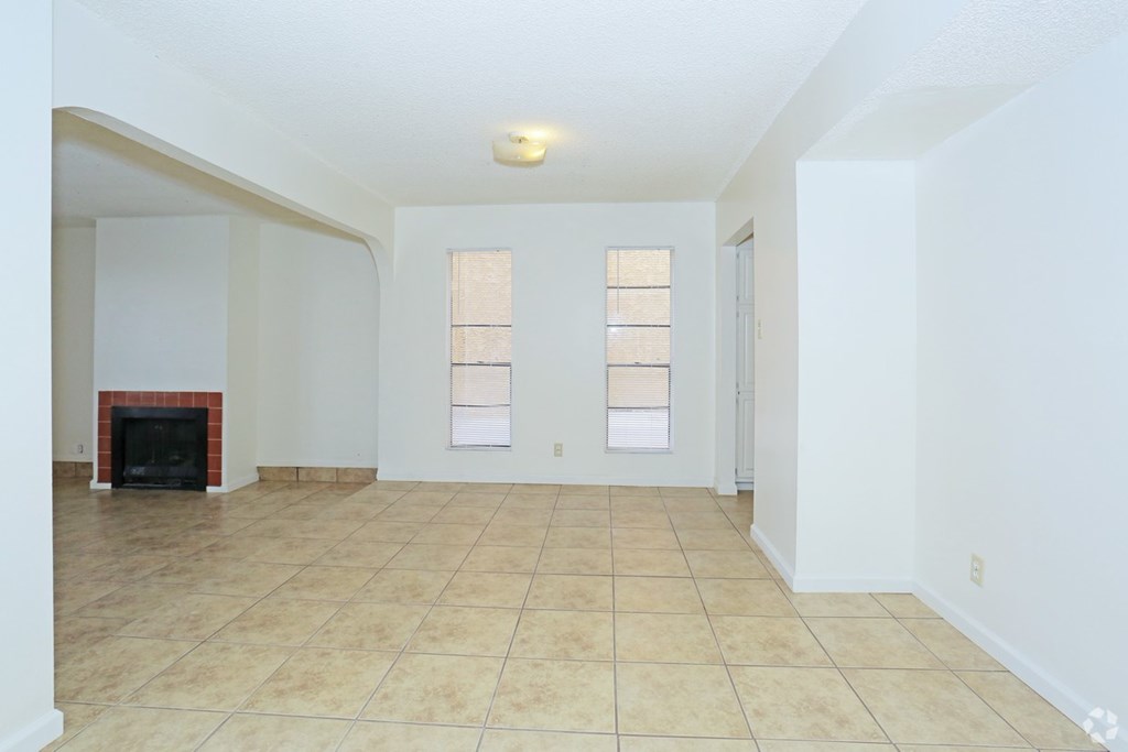 A room with a fireplace and tiled flooring.