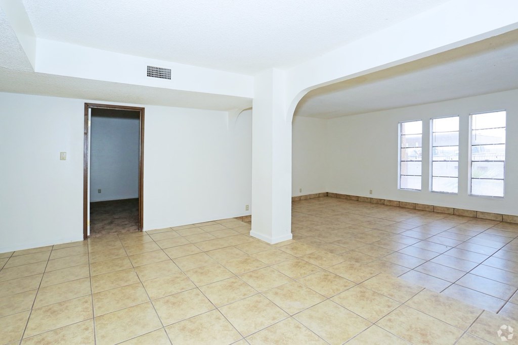A room with tiled flooring and a doorway leading to another room.