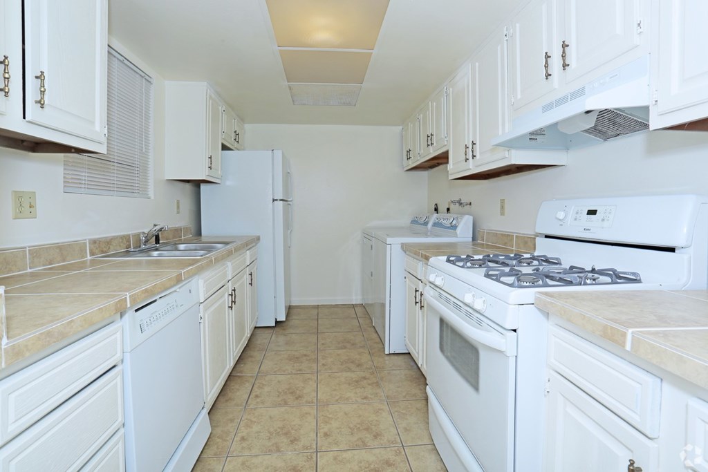 A kitchen with white appliances and cabinets.