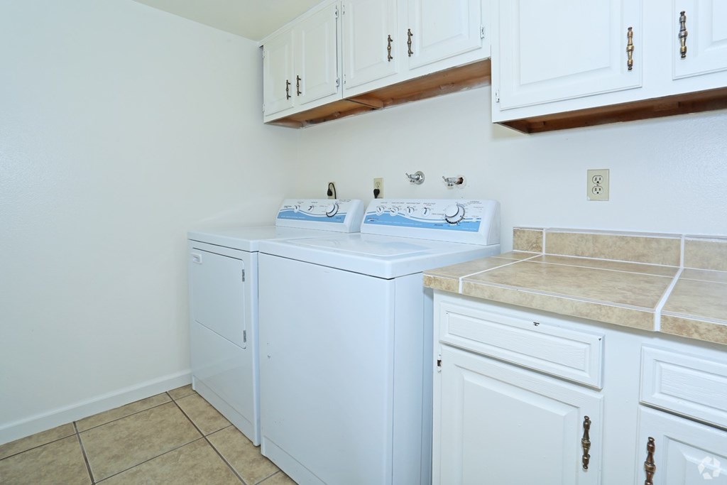 A white washing machine and dryer in a small laundry room.