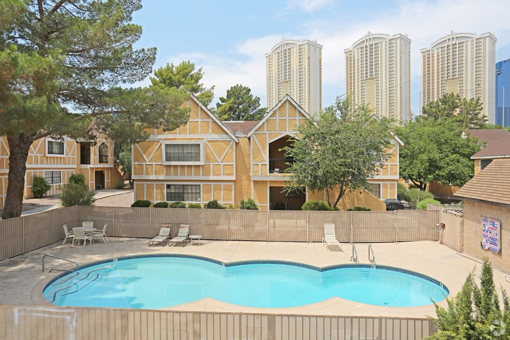 A pool in a backyard with a house in the background.