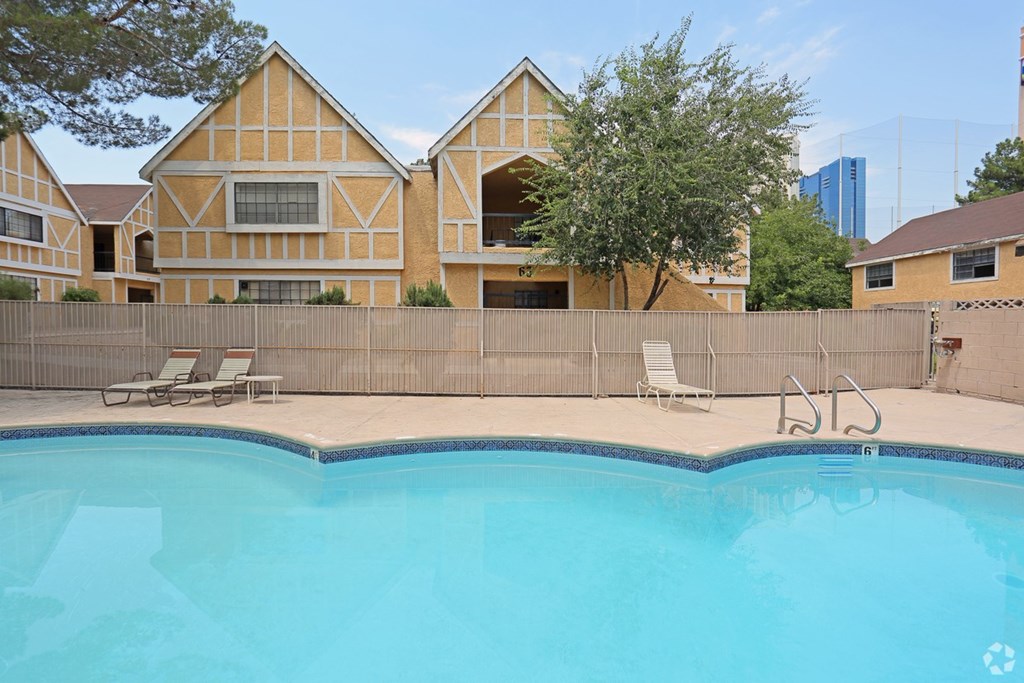 A swimming pool in front of a building with a yellow facade.