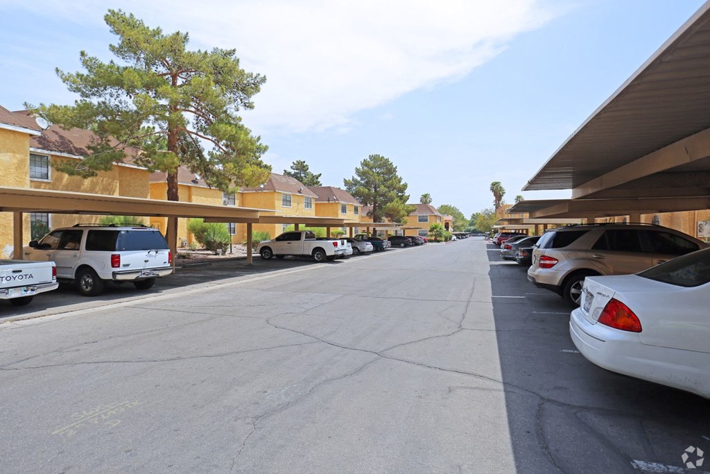 A parking lot with cars and a building in the background.