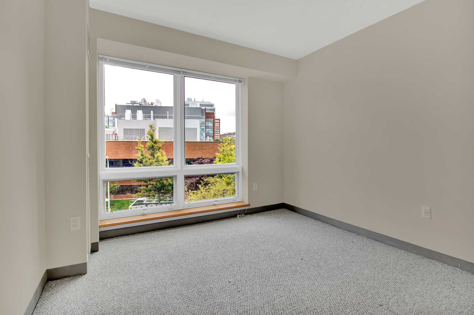 Bedroom featuring large windows and skyline views