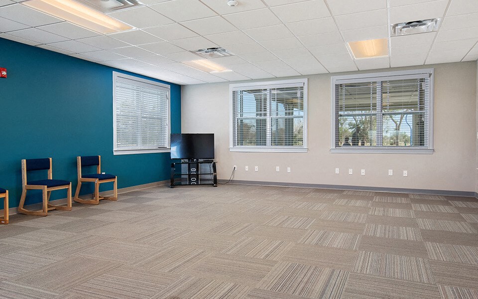 an empty room with chairs and a tv