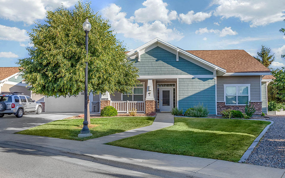 a blue house with a tree in front of it
