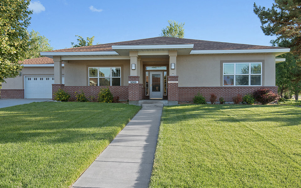 a house with a lawn and a sidewalk in front of it