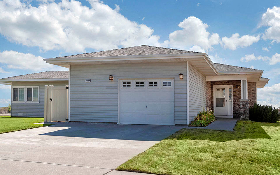a white house with a white garage door and a driveway