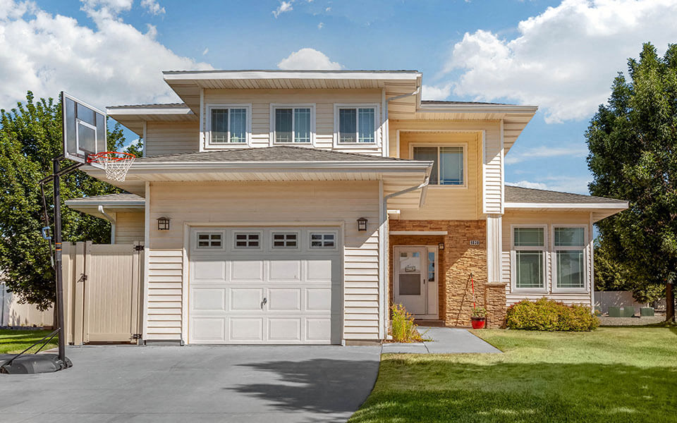 a tan house with a white garage door