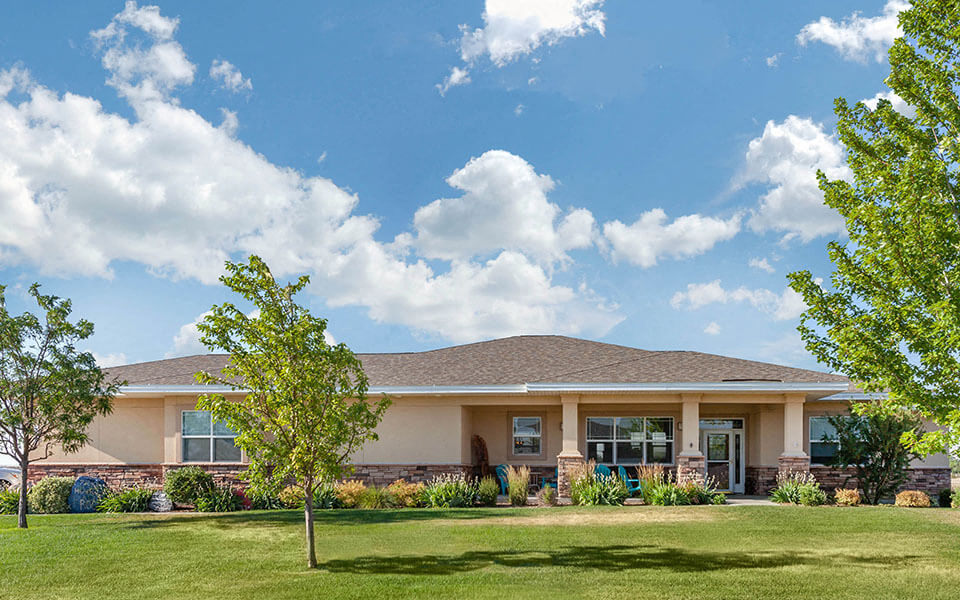 the exterior of a house with a lawn and trees