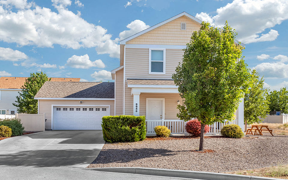 a beige house with a tree in front of it