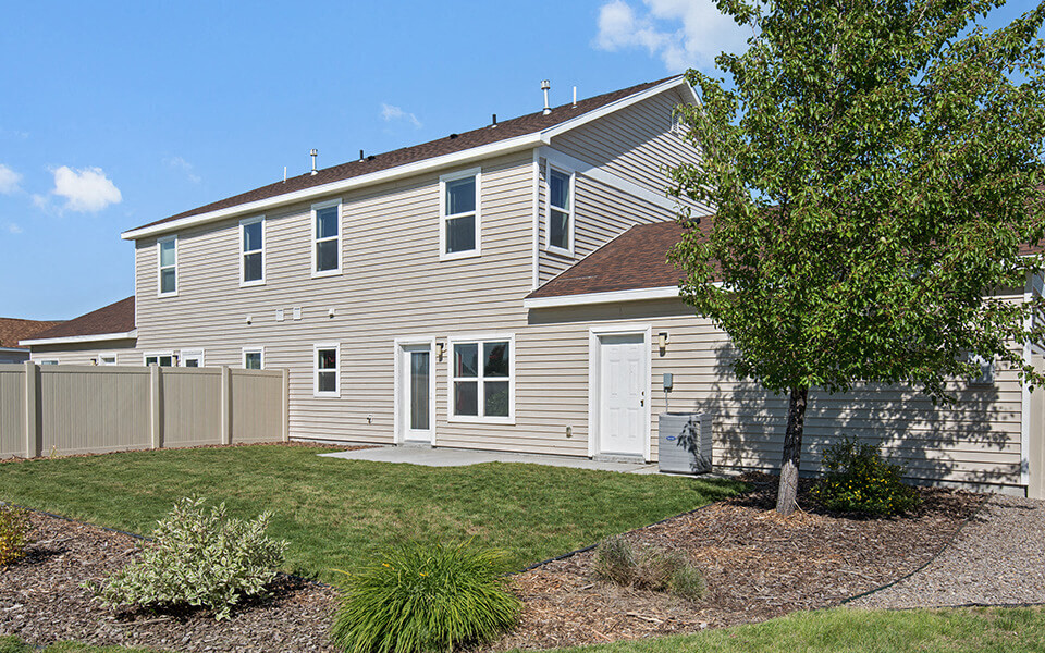 a white house with a yard and a tree