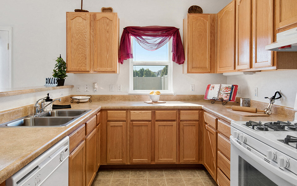 a kitchen with wooden cabinets and a sink and a window
