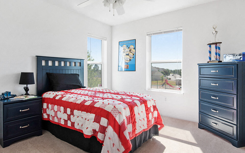 a bedroom with a bed and two windows