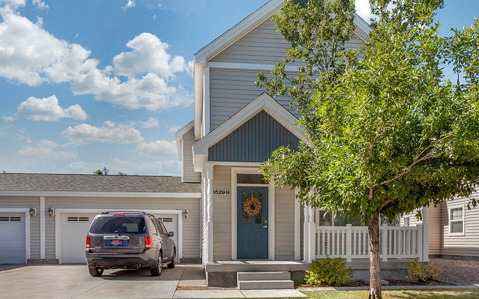 the front of a home with a car parked in the driveway