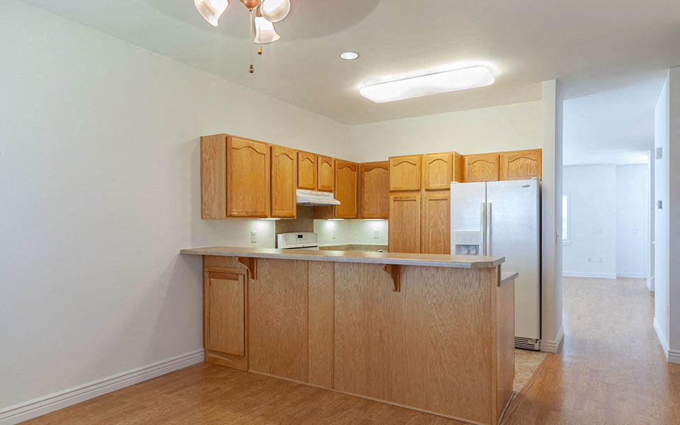 a kitchen with wooden cabinets and a refrigerator