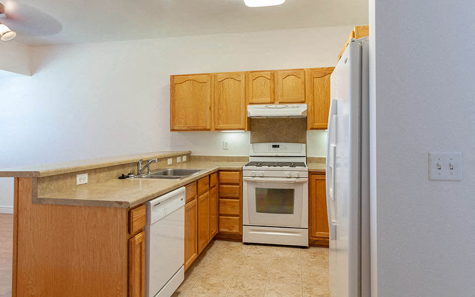 a kitchen with a stove refrigerator and sink