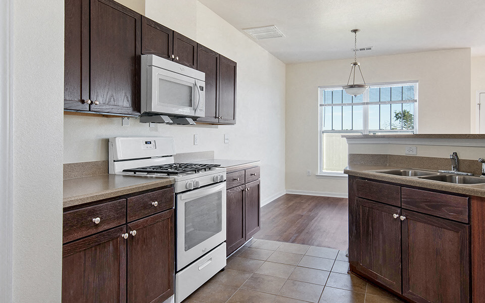a kitchen with wooden cabinets and white appliances
