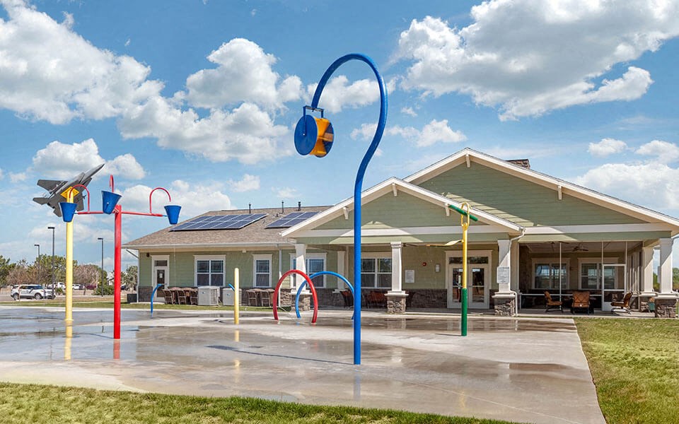 a large playground in front of a building with a parking lot