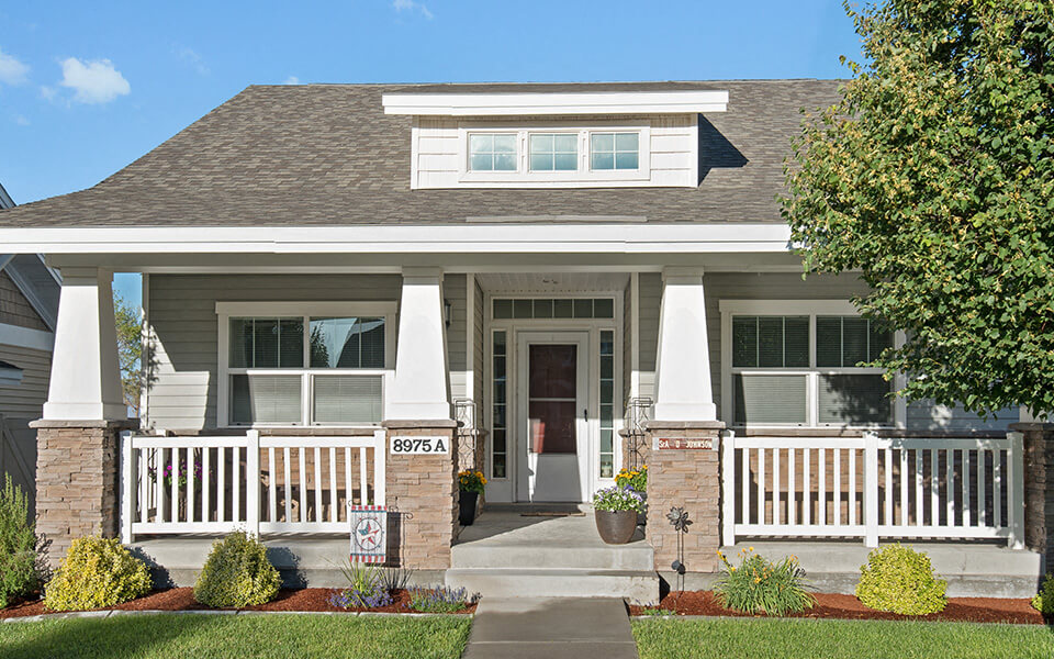 a house with a porch and a sign in front of it