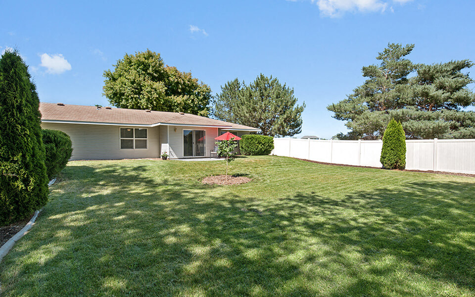 a house with a large yard and a white fence