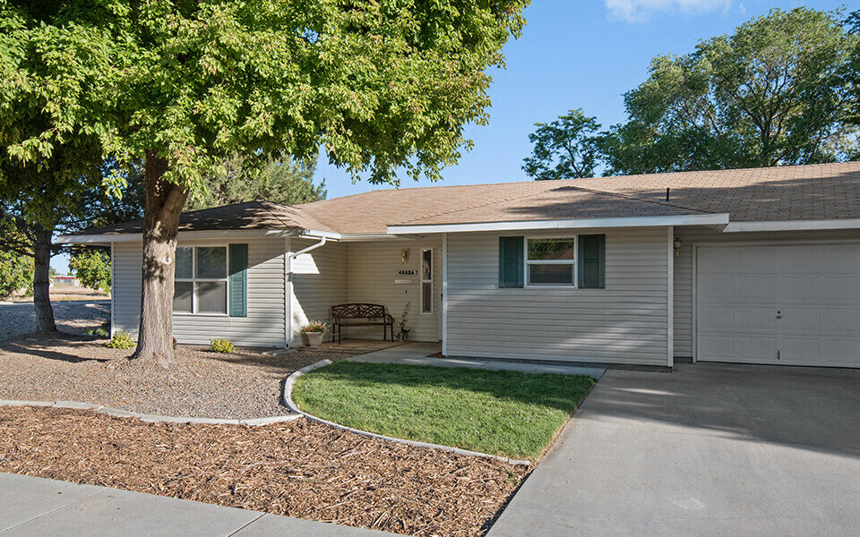 a white house with a tree in the front yard