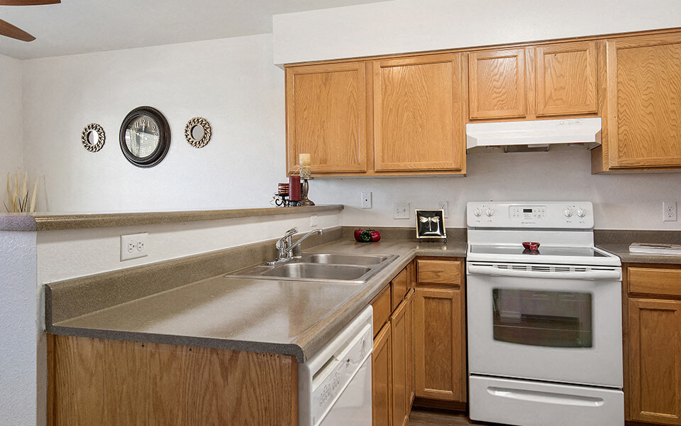 a kitchen with a sink stove and oven and wooden cabinets