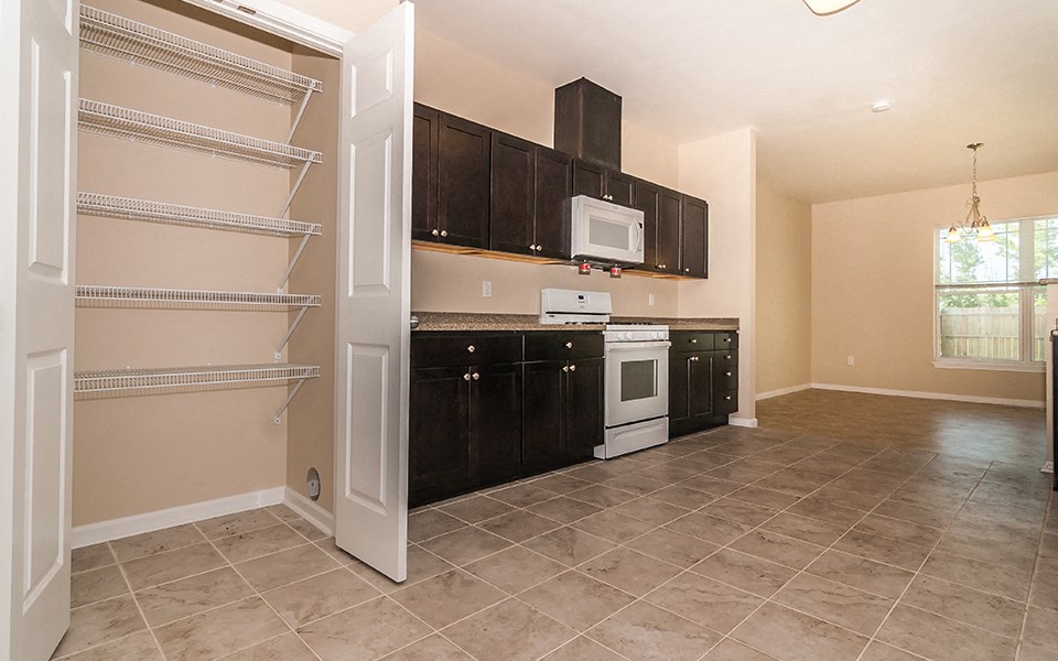a kitchen with black cabinets and white appliances and a white microwave