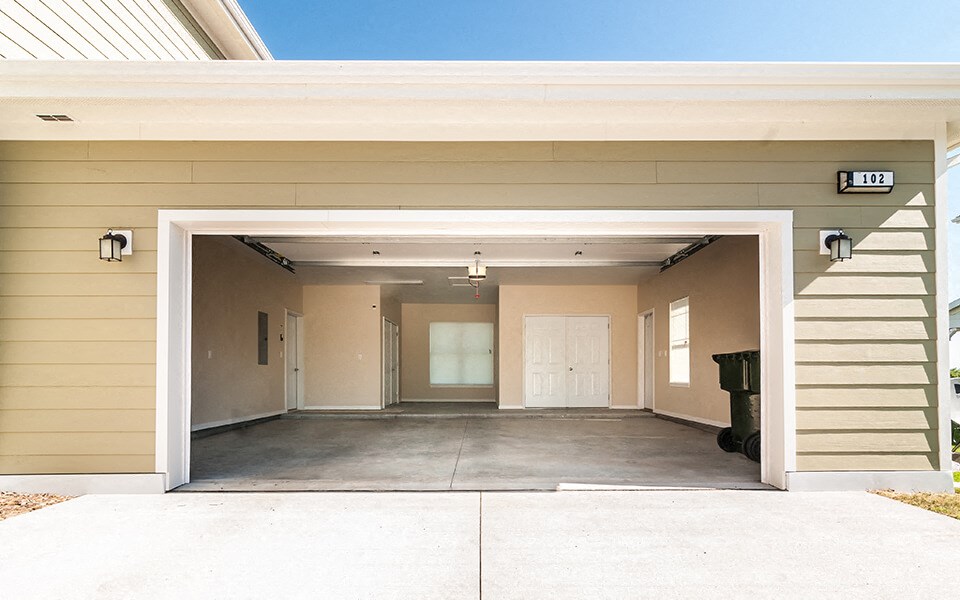 the entrance to a garage with a driveway and a white door