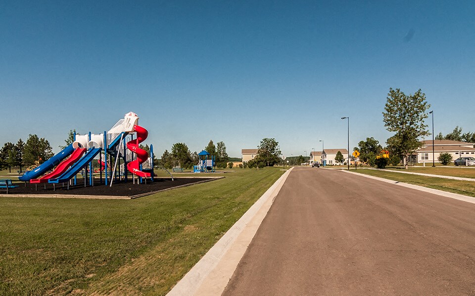 a playground with a slide on the side of a road