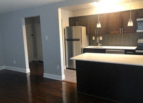 A kitchen with a black counter and a white fridge.