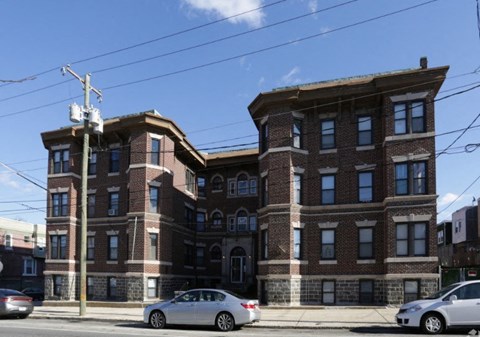 A large brick building with a car parked in front.