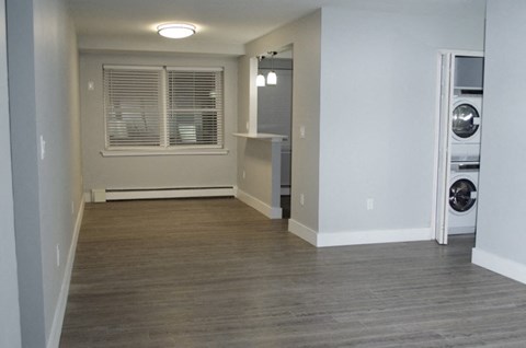 A room with a window and a washing machine.