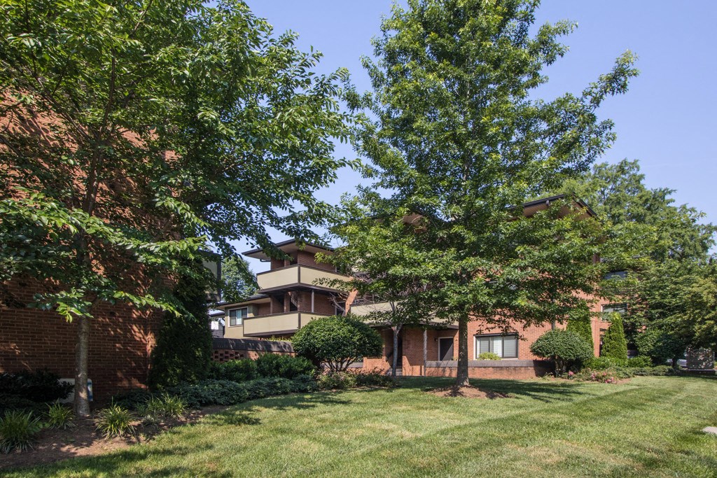 a house with a yard and trees in front of it