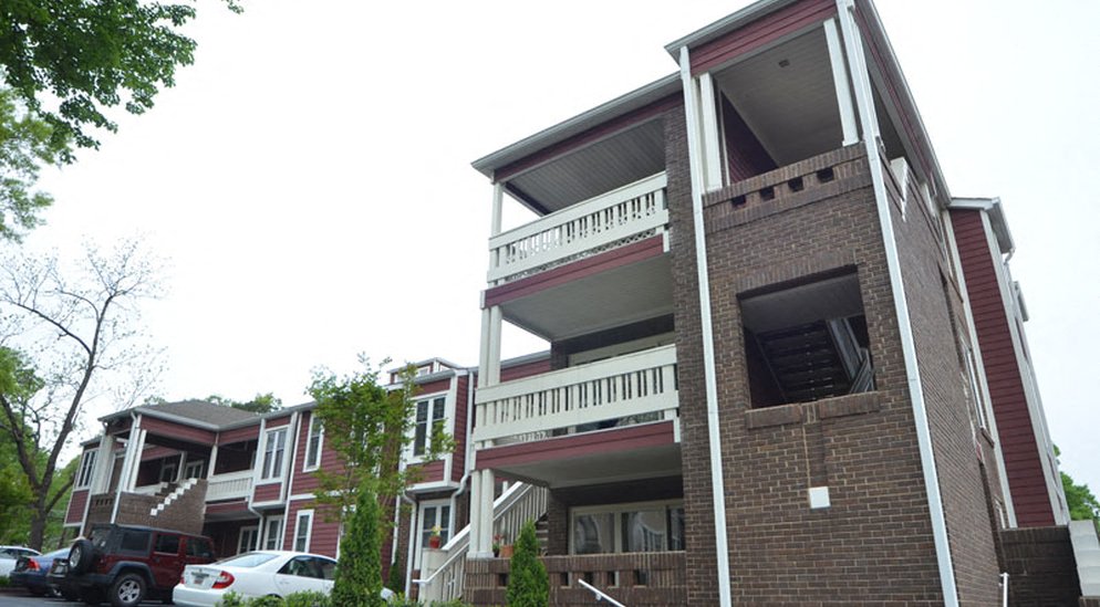 the apartment building is shown with cars parked in front of it