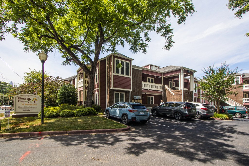 a parking lot with cars in front of an apartment building