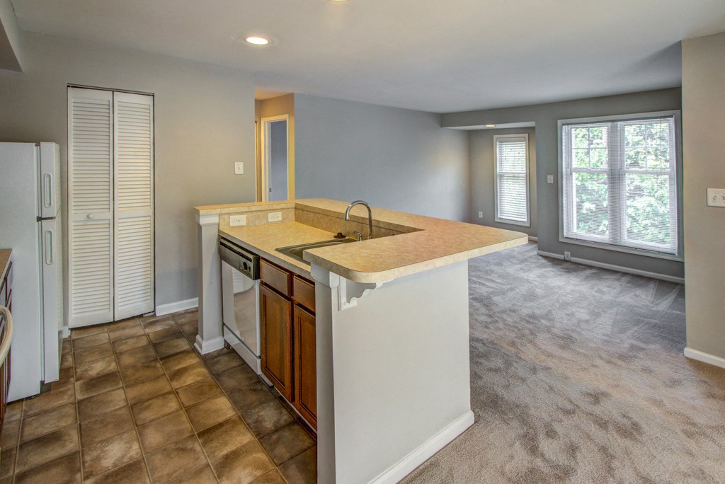 an empty kitchen with a sink and a counter top