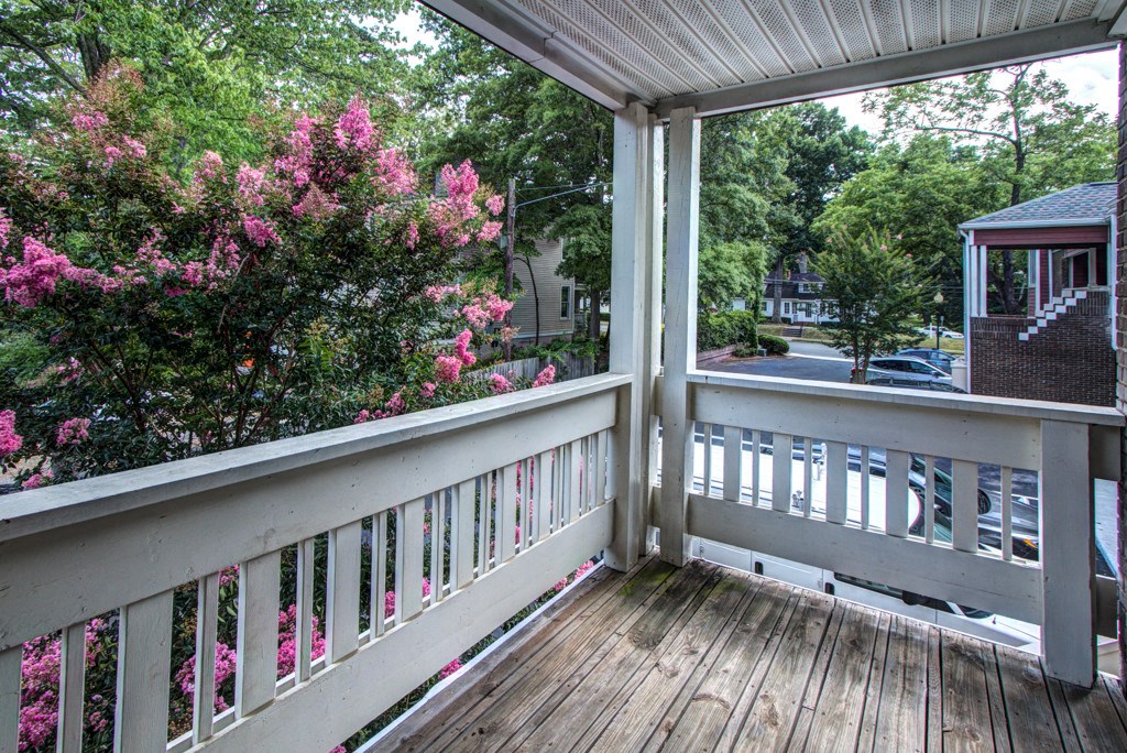 a balcony with a view of trees and a house