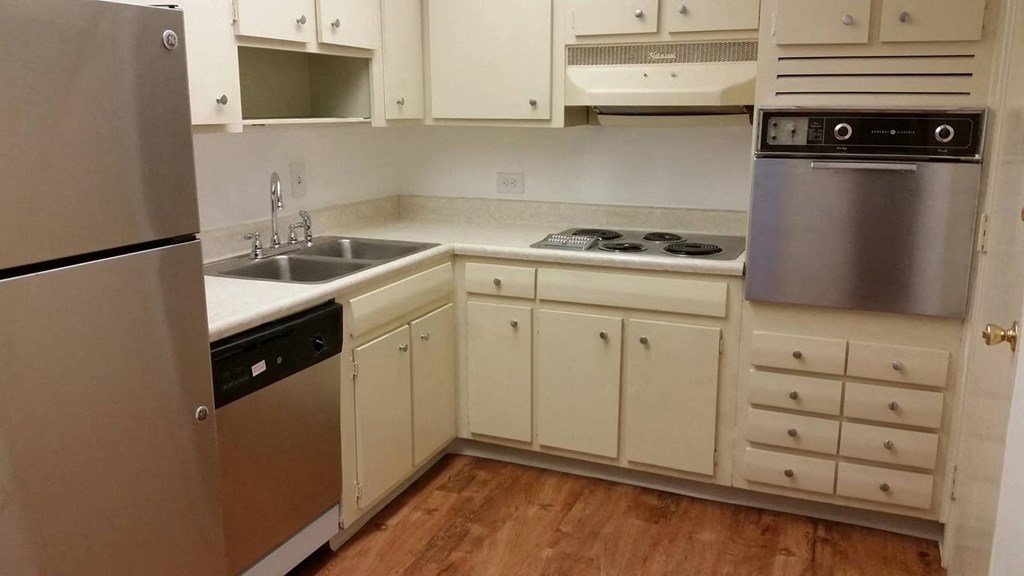 a kitchen with white cabinets and stainless steel appliances