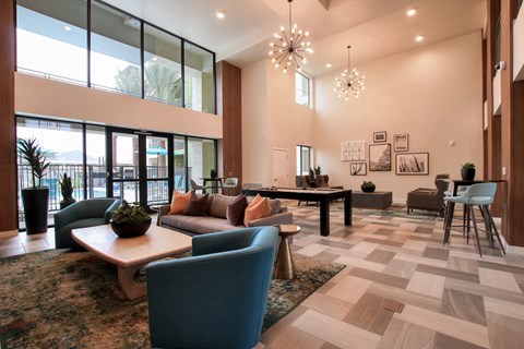 A spacious living room with a large rug and a variety of seating options.