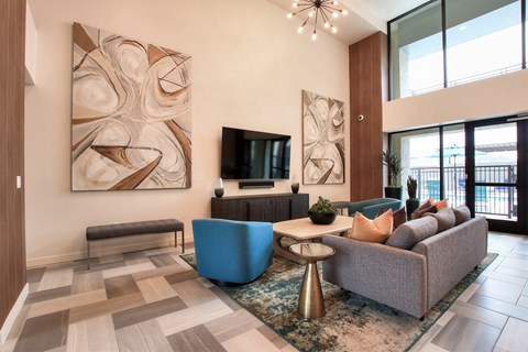 A living room with a blue chair and a grey couch.