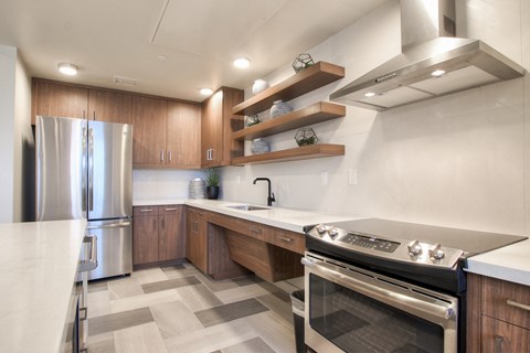 A modern kitchen with a stainless steel refrigerator and a stove top oven.