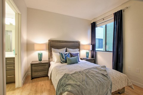 A bedroom with a large bed and two nightstands with lamps.