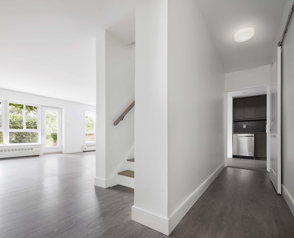 Entry hallway with stairs with living room in the background
