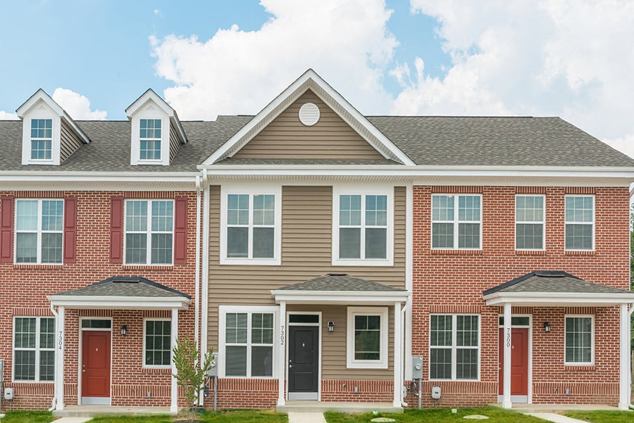 A row of houses with red and beige exteriors.