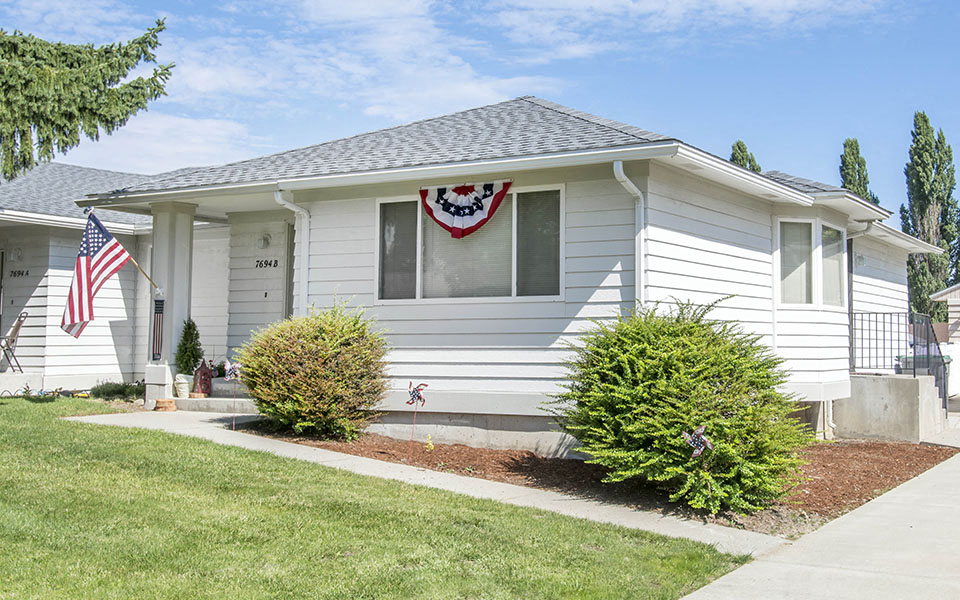a white house with an flag on the window